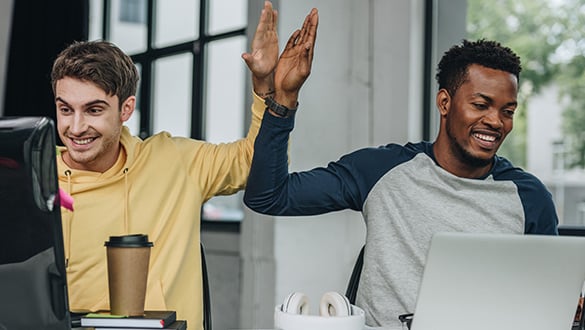programmers giving high five while working in office together