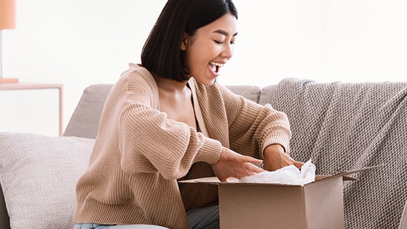 woman unpacking parcel after online shopping